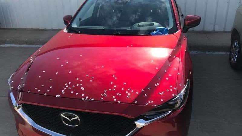 red mazda with with white paint spots